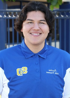 Male student wearing school blue poloshirt with school logo